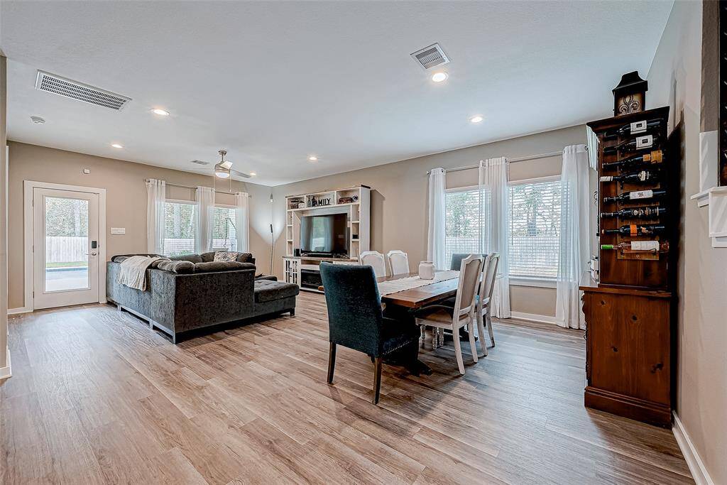 Discover the inviting open layout from the staircase, seamlessly connecting the family room and dining area, all overlooking a serene backyard.