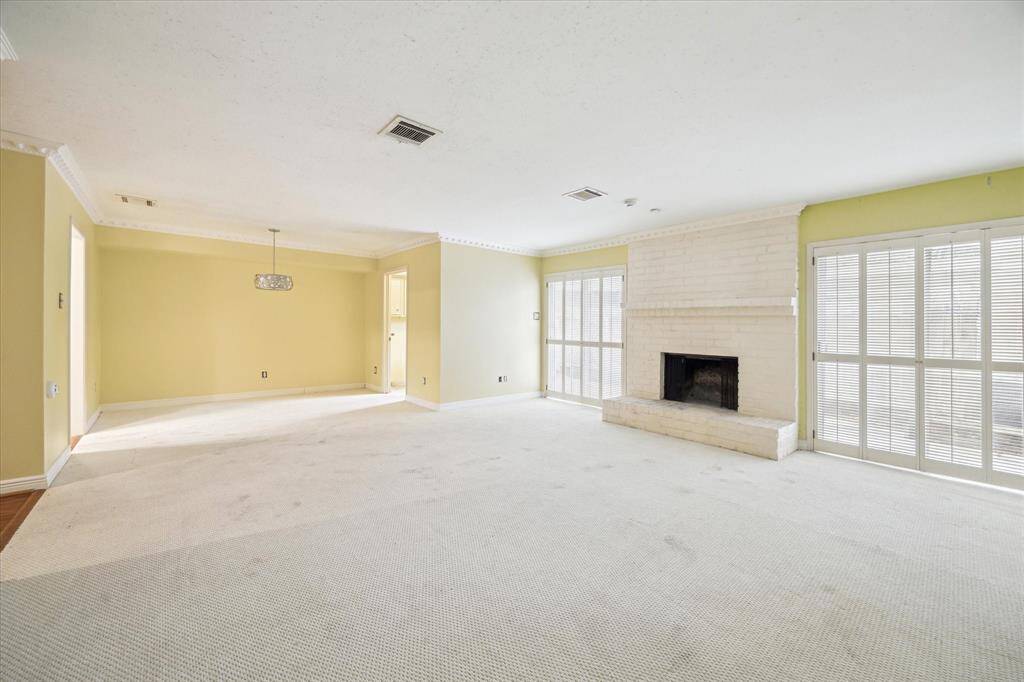 Bright and airy family room with large windows and cozy wood-burning fireplace.