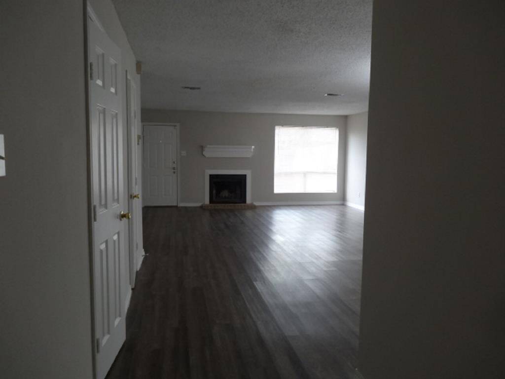 Laminate Flooring Downstairs w/Glimpse of Large Family Room & Spacious Closets to the Left