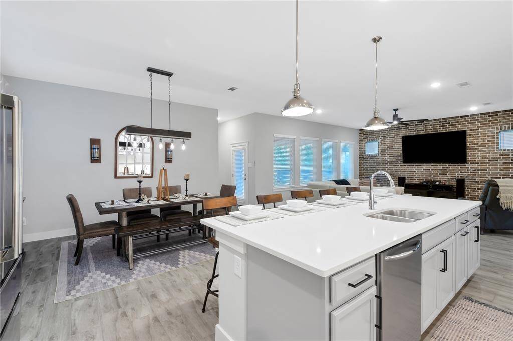 This home has loads of character!    Notice the brick accent wall in the living room, the stylish lighting, durable flooring, and bright sunny windows.