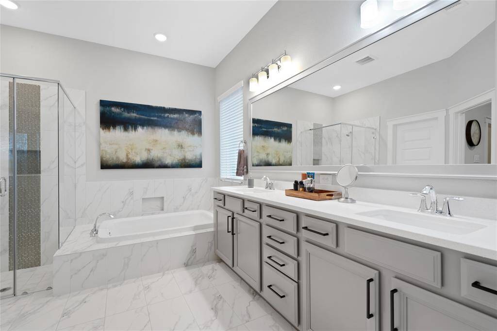 Stunning primary suite bathroom with huge soaking tub, spacious walk in shower, and look at all the counter and storage this bathroom has!