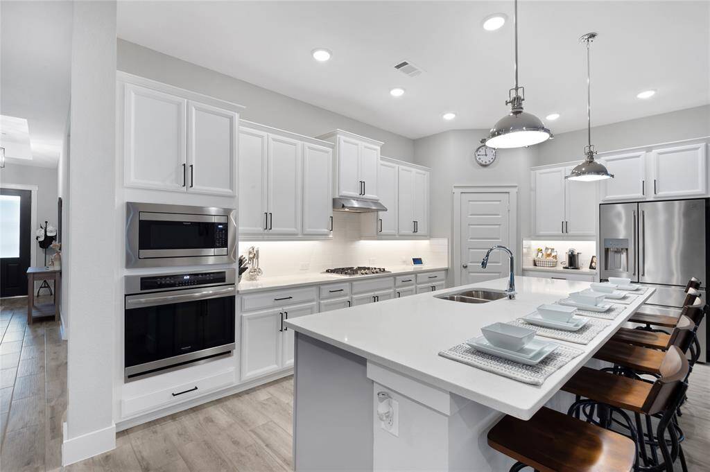 WOWZA!   What a dynamic kitchen that has everything you are looking for.   Light and bright and fresh in styling, gas cooktop, stainless steel appliances, oversized island that you can see fits 5 comfortably, and open to the large dining space and living room as well.