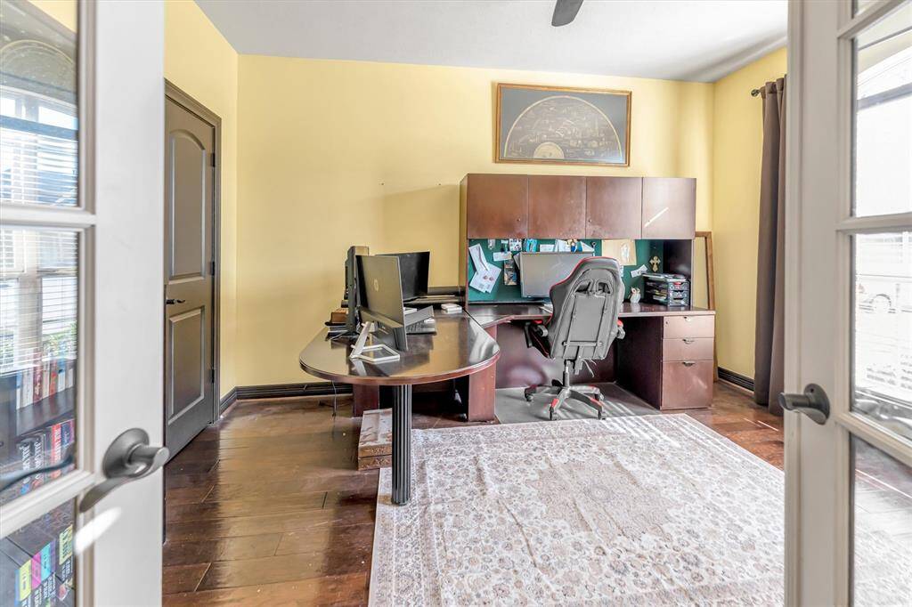 Bright home office with wooden floors and abundant natural light offering a cozy, productive atmosphere.
