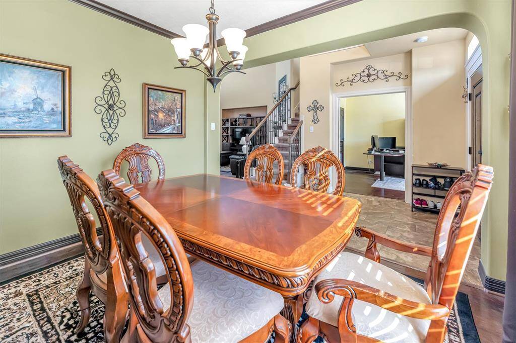 Elegant dining room features a stylish chandelier and opens to a staircase and home office, creating a spacious, inviting atmosphere.