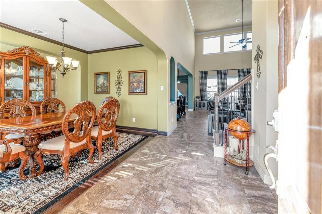 Experience the charm of this open-concept space, featuring a classic dining room. The high-ceilinged living room, bathed in natural light from large windows, offers an inviting atmosphere for entertaining.
