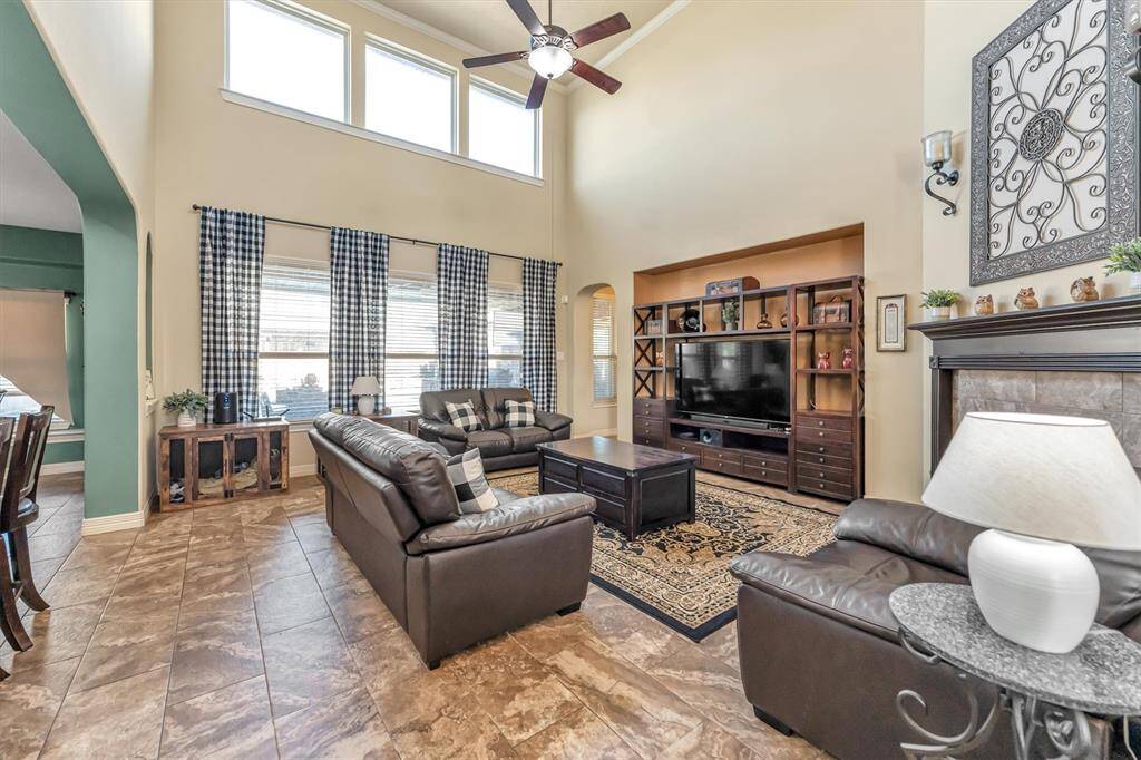 Experience the charm of this bright, spacious living room with soaring ceilings and large windows. Enjoy spacious  seating, a stylish fireplace, and entertainment center possibilities. The open layout seamlessly connects to the dining area, perfect for entertaining.