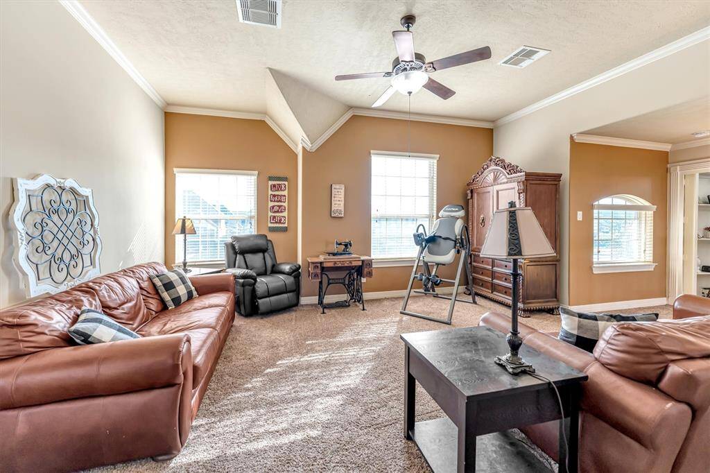 Experience the inviting charm of this living room with its high ceilings, abundant natural light, and warm beige tones.
