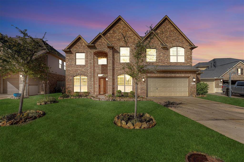 Discover this charming two-story brick home featuring a three-gabled roof, two-car garage, and spacious driveway. Enjoy large, inviting windows and a beautifully maintained lawn with a delightful garden.