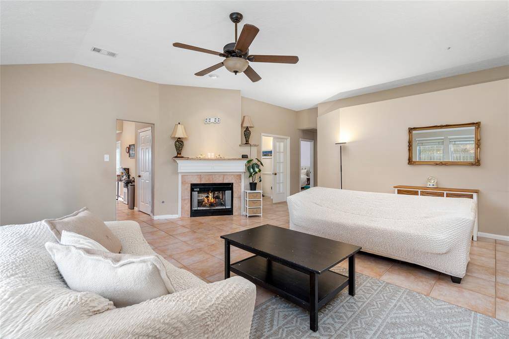 The living room features a beautiful double-sided fireplace, offering warmth and a cozy ambiance that flows throughout the space. Whether you're curled up on the couch with a book or spending time with loved ones, the fireplace adds a comforting, homey touch—perfect for creating a welcoming atmosphere during the winter months.