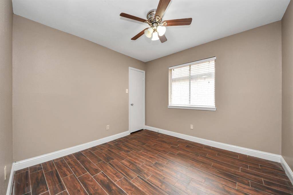 Guest bedroom with big picture window and ceiling fan.