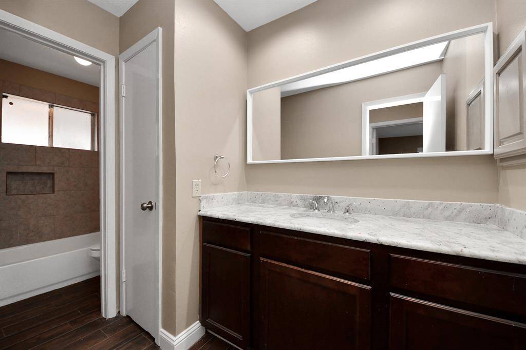 Guest bath has tub/shower combo and linen closet for storage.
