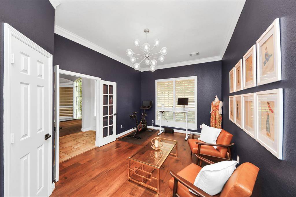 Study/second bedroom down stairs features plantation shutters and beautiful hardwood floors.
