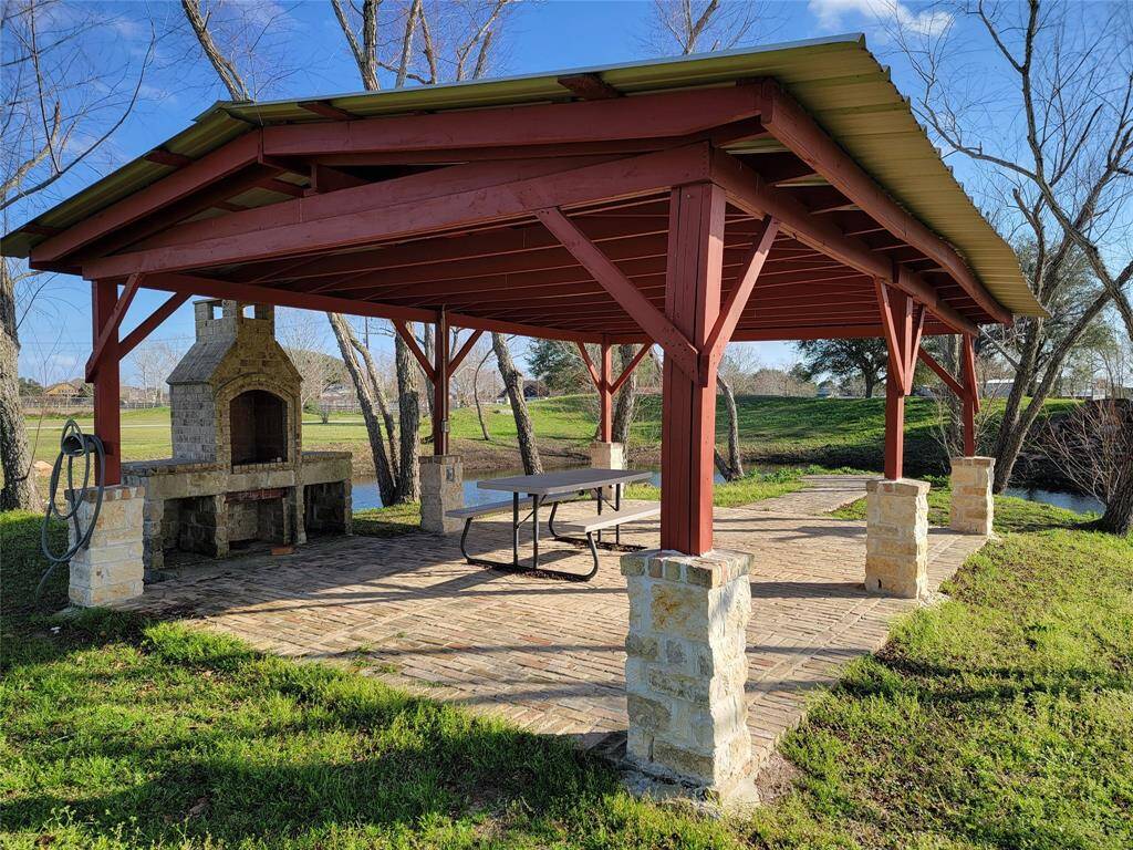 Pavilion with outside kitchen adjacent to pond.
