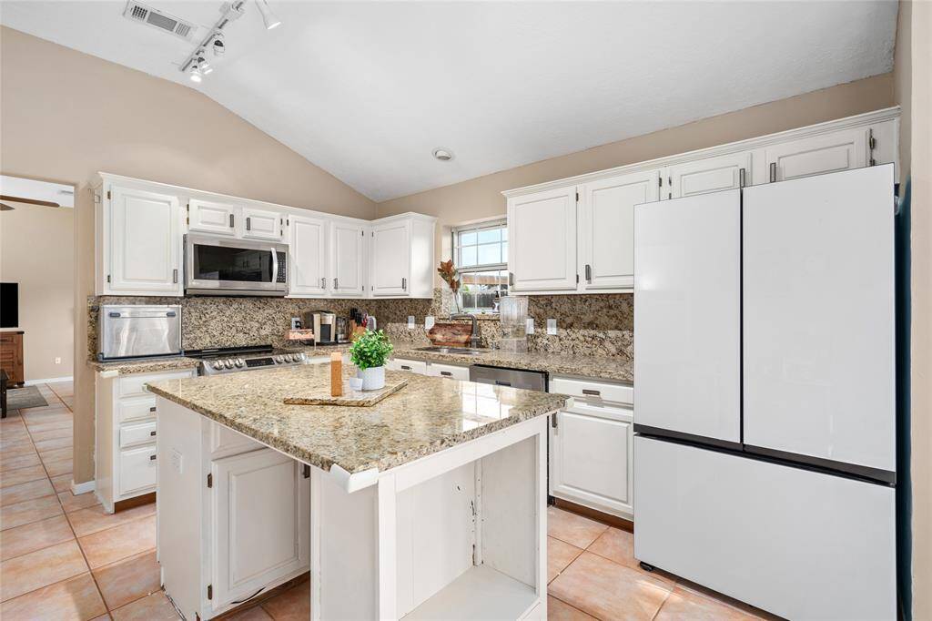 The kitchen featuring modern appliances, ample cabinetry, and spacious countertops, perfect for preparing meals and entertaining. With an open layout that flows seamlessly into the breakfast and dining areas, it offers both functionality and style, making it the ideal space to gather with family and friends.