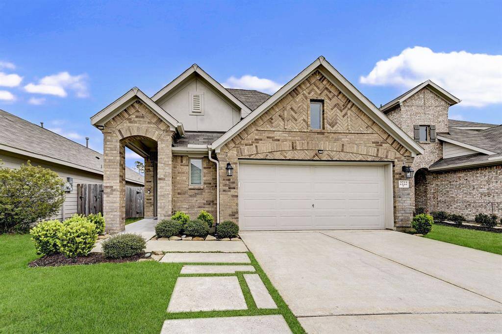 This charming home features a brick exterior with a welcoming front porch. It has a two-car garage and a well-maintained lawn, providing great curb appeal in a friendly neighborhood setting.