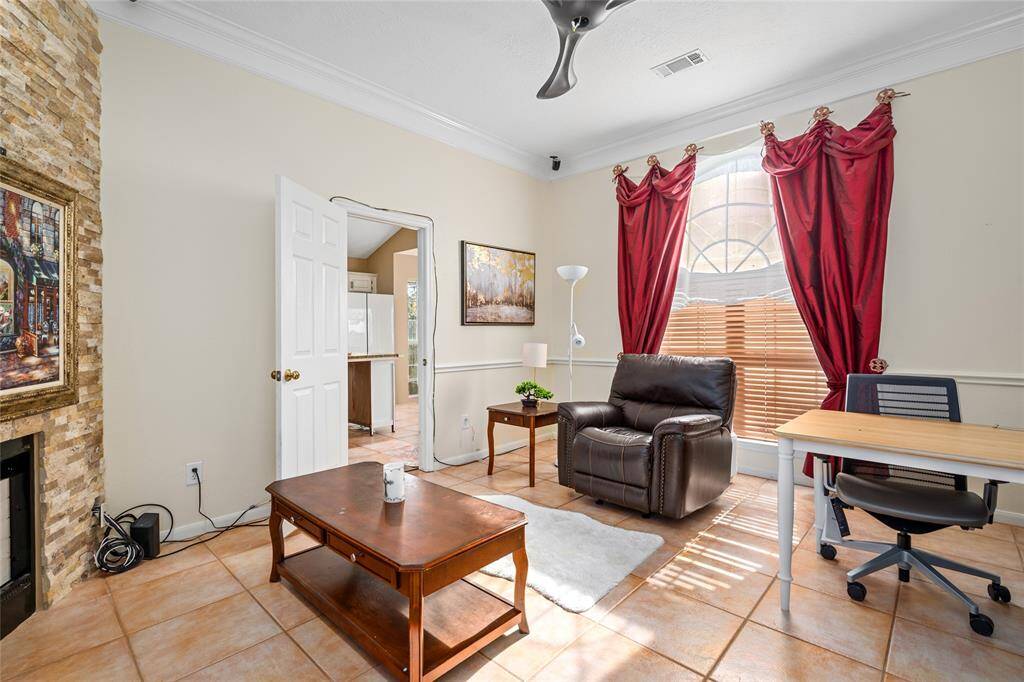 This room is currently being used as a home office, featuring a large window that brings in plenty of natural light. With doors on both sides—one opening to the kitchen and the other to the living room—this versatile space can easily be converted into a formal dining room, game room, or any space that suits your lifestyle. The possibilities are endless, making it perfect for whatever your needs may be.