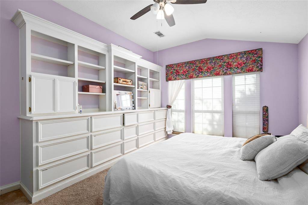 The primary bedroom is the perfect place to unwind after a long day. Spacious and serene, it features soft carpet, built-in cabinets for extra storage, and light-colored paint tones that create a calm, soothing environment, making it an ideal retreat for rest and relaxation.