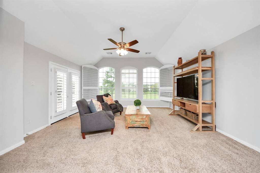 Exit the elegant French doors and step onto this spacious wooden deck overlooking a lush golf course. Ideal area for enjoying serene views and outdoor relaxation.