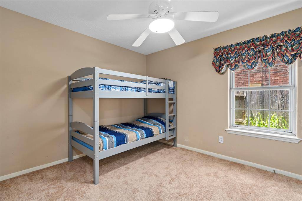 One of the secondary bedrooms features soft carpet and earthy tones, providing a versatile canvas that's easy to personalize. Whether it's for a guest room, home office, or a creative space, the neutral palette allows you to make it your own with ease and style.