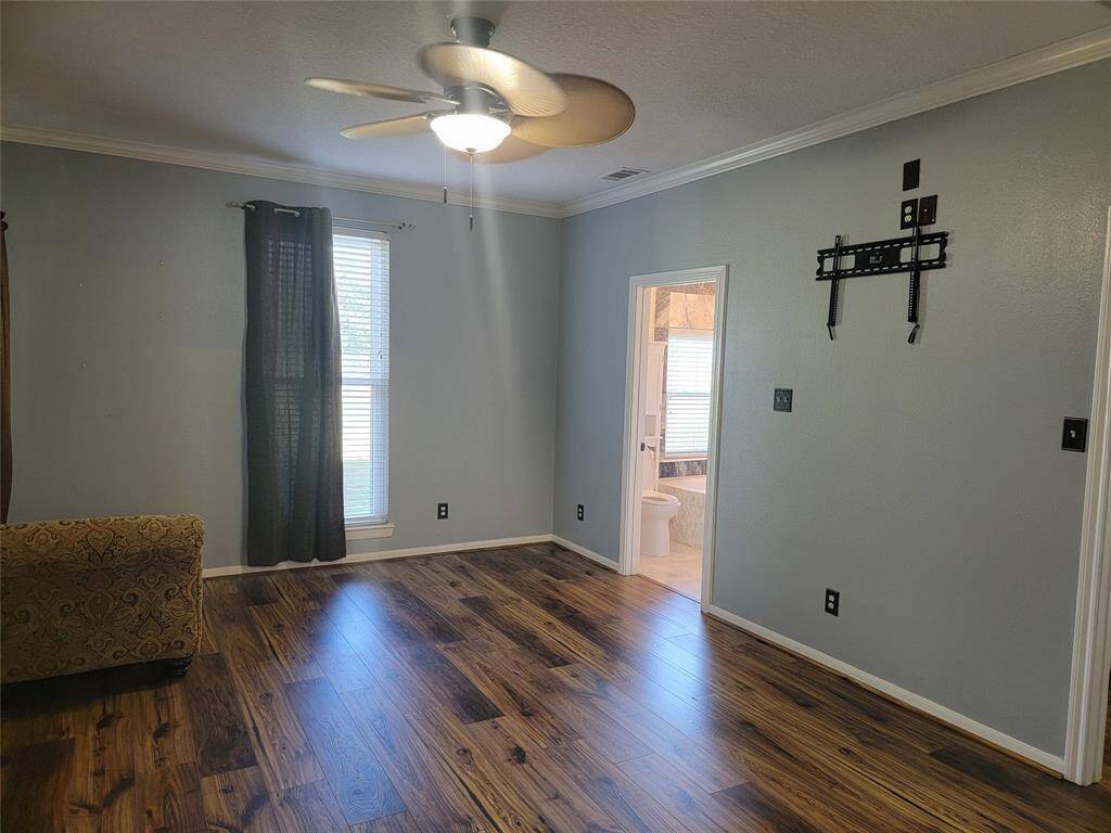Primary bedroom with tasteful laminate flooring.