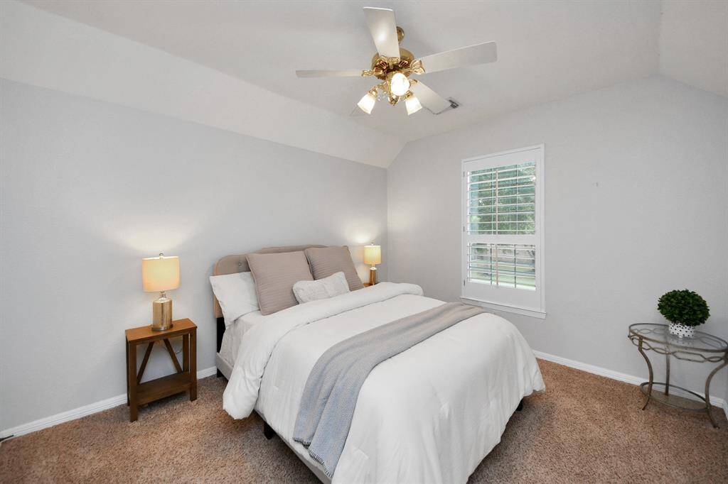 Third bedroom upstairs with lots of natural light from the large window featuring plantation shutters.