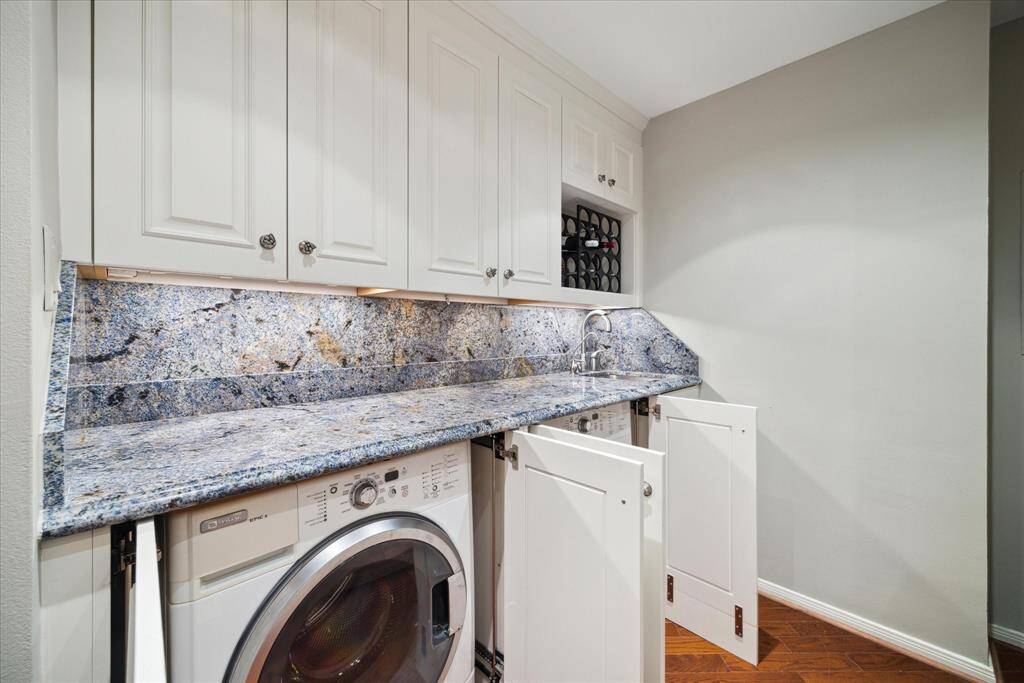 Washer and dryer area with counter space located in storage space at end of kitchen.