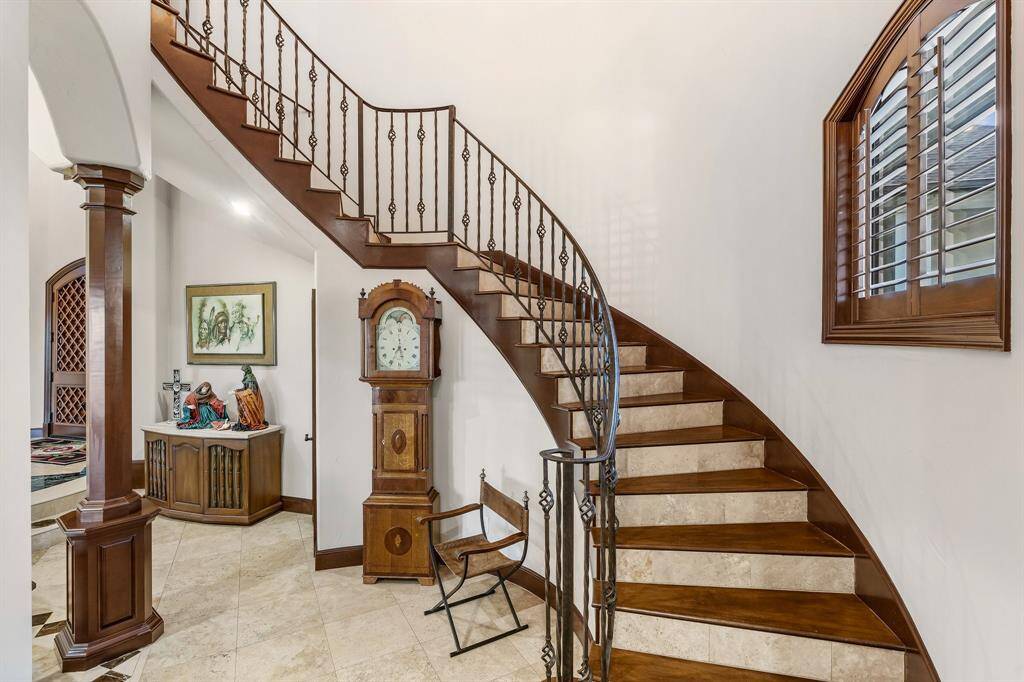 Grand curved staircase with elegant detailing, creating a striking focal point in the entryway.