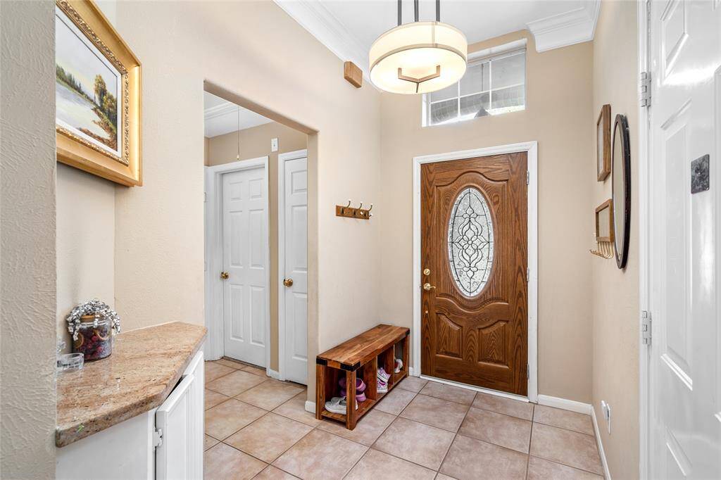 As you enter, you'll find a hallway to the right leading to one of the bedrooms. Just beside it, a cozy sitting area offers the perfect spot to slip off your shoes and unwind after a long day.