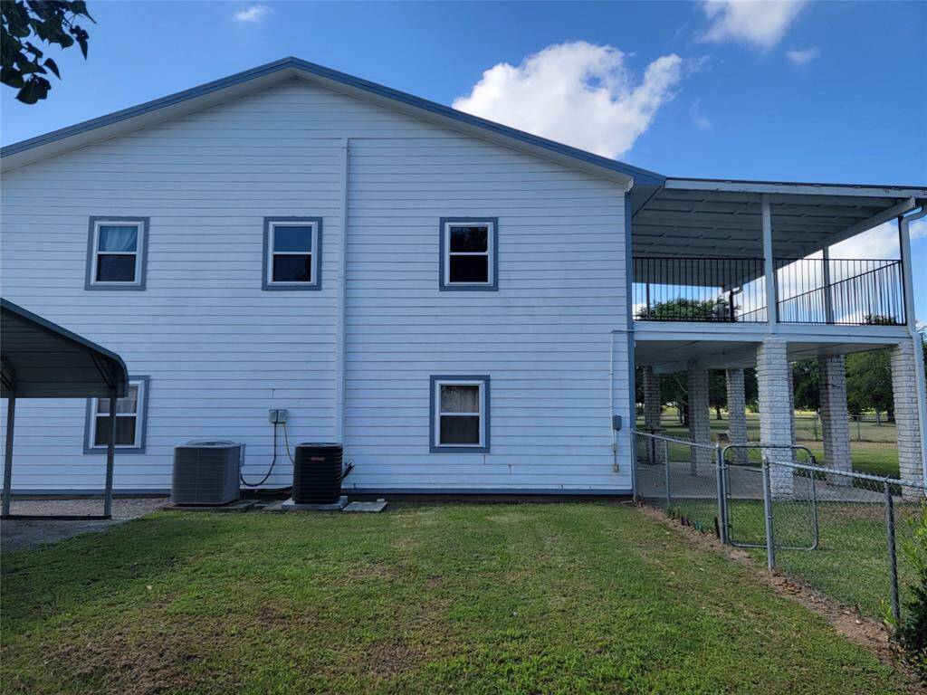 Side of 2 story home showing the 2 AC compressors.