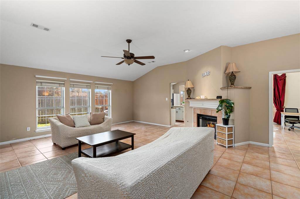 The living room features a stunning wall of windows that flood the space with natural light, creating a bright and airy atmosphere. The cozy fireplace adds warmth and charm, making it the perfect spot to relax and unwind.