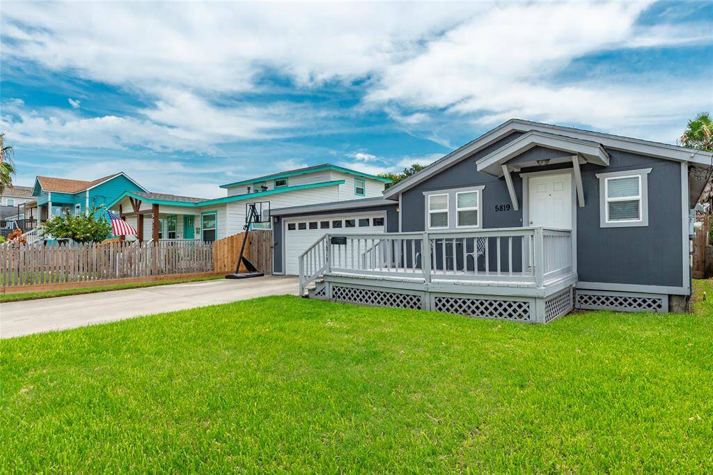 Welcome to 5819 Avenue R this single-story home featuring a white-trimmed front deck, an attached garage, and a well-maintained lawn.