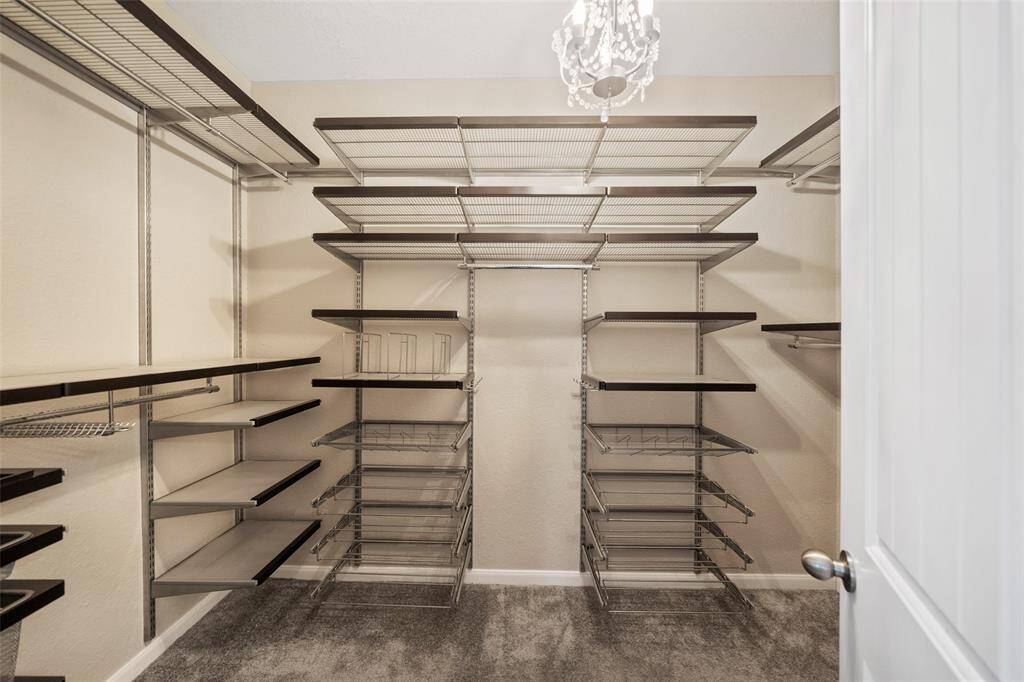 Primary walk in closet has Elfa closet organizer system