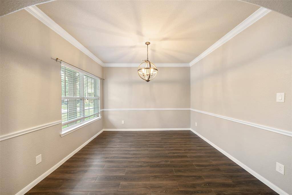 Formal dining room is located off foyer and ha chair rail , crown molding and durability of tile floors but stylish look of wood floors