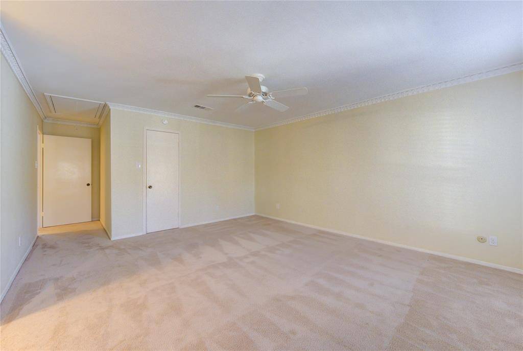 Spacious primary bedroom with soft carpet, crown molding, and an ensuite bath for ultimate comfort and style.