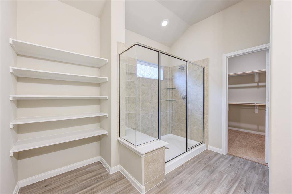 Which features plenty of shelving for personal items and a large shower ...