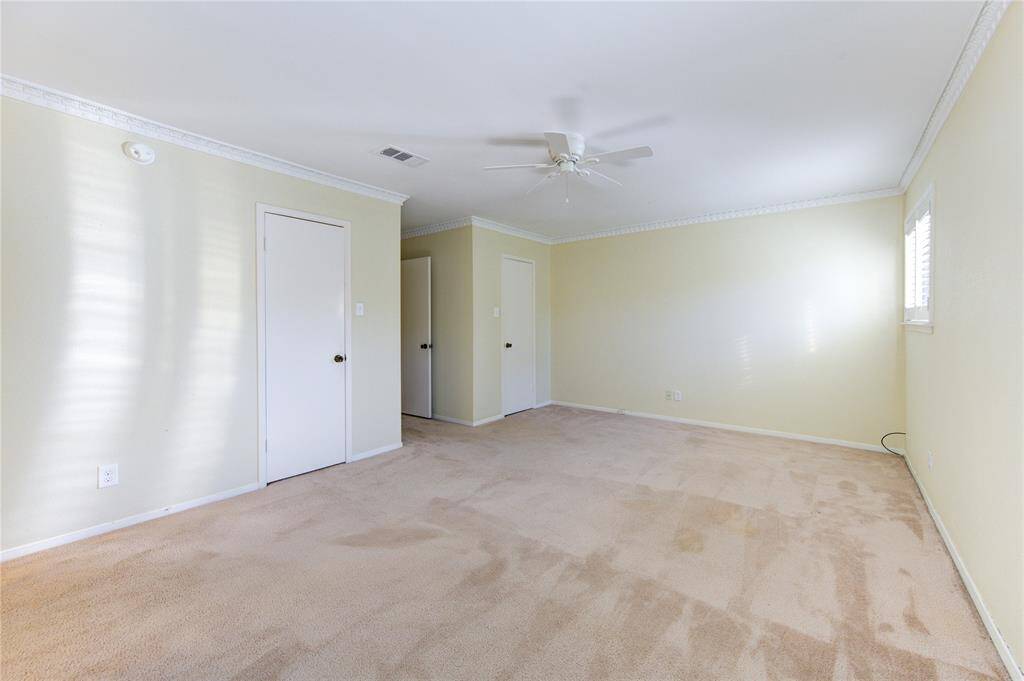 Spacious Primary bathroom with a glass-enclosed shower, and tub. Features light yellow tiles and modern fixtures, creating a bright and inviting space.