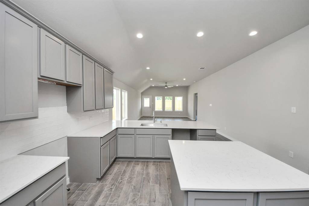 The kitchen is a culinary haven, featuring granite countertops, a tile backsplash, stainless steel appliances, and 42” upper cabinets.