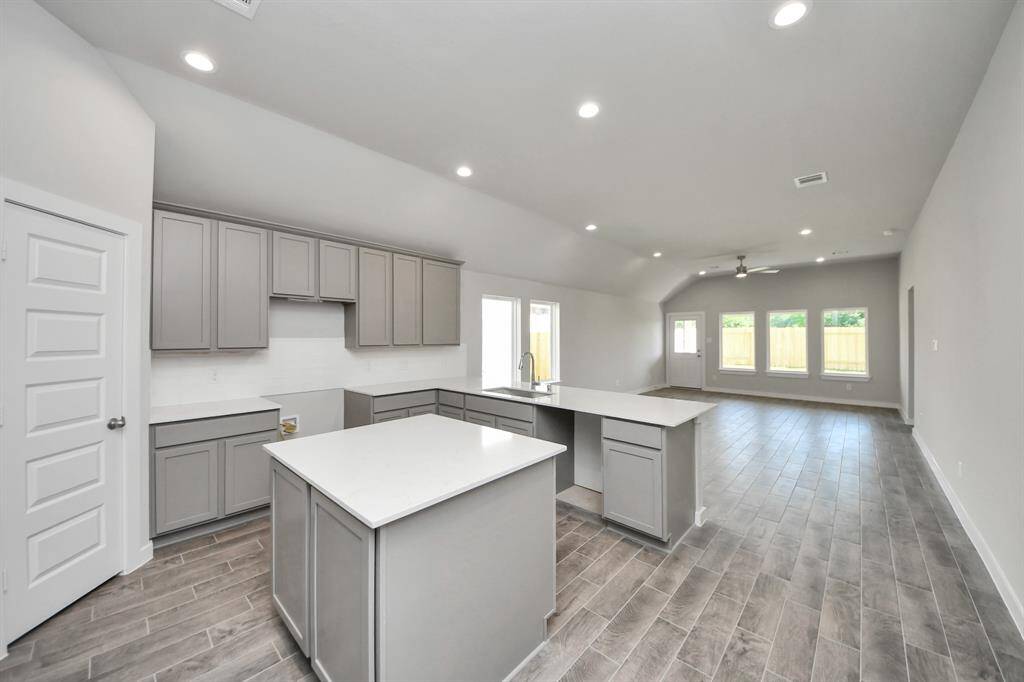This generously spacious kitchen is a dream realized! With high ceilings, soft close cabinets, granite countertops, stainless steel appliances (To be Installed), a sleek tile backsplash, recessed lighting, and an extended counter area, it offers both style and practicality. All this opens up to the expansive family room, creating a perfect hub for gatherings.