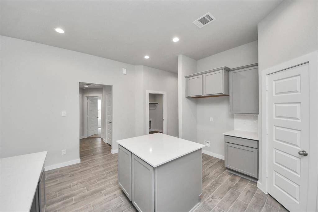 Discover another perspective of this stunning kitchen, generously appointed with an abundance of counter space