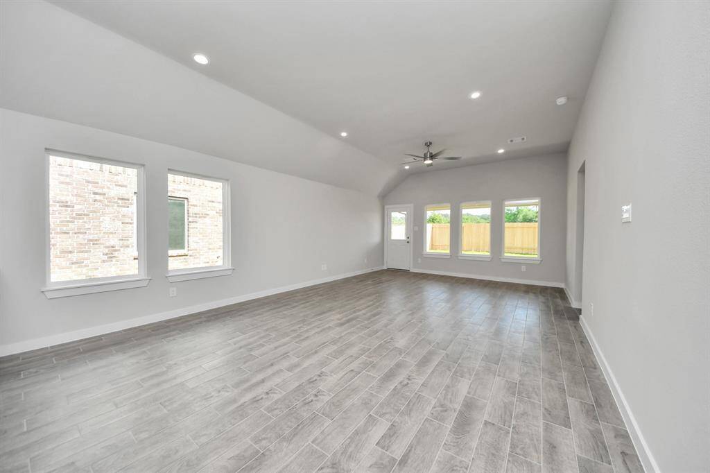 Gather the family and guests together in your lovely living room! Featuring soaring high ceilings, recessed lighting, ceiling fan, custom paint, gorgeous floors, and large windows that provide plenty of natural lighting throughout the day.