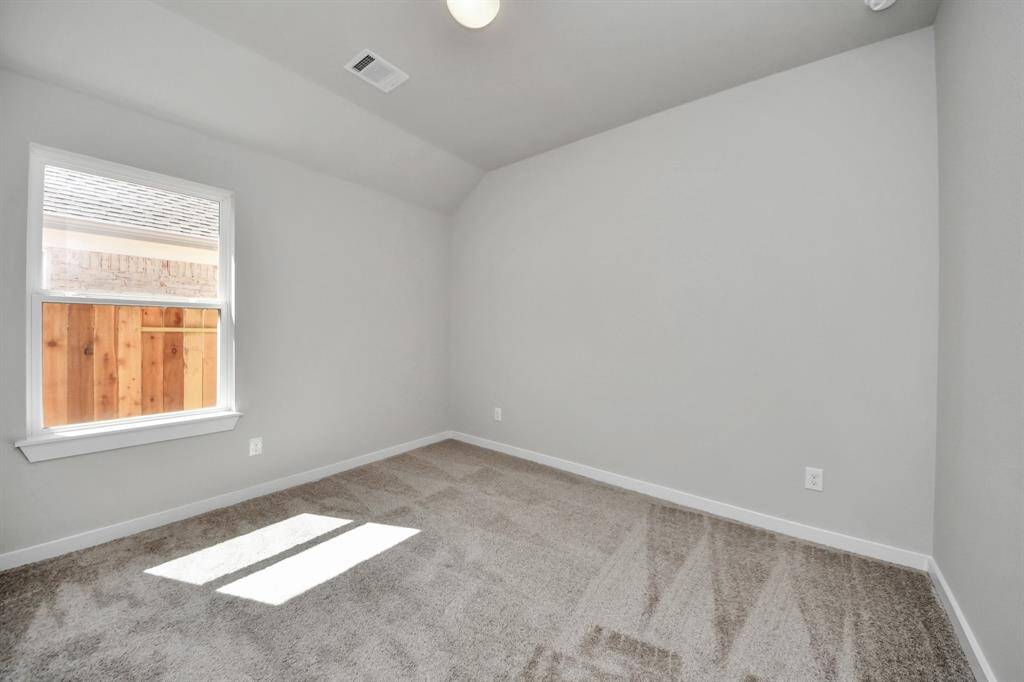 Secondary bedroom features plush carpeting, large windows that let in plenty of natural light, bright paint, and spacious closets.