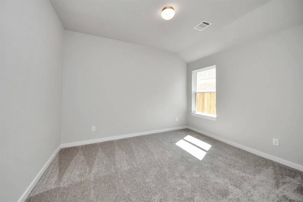 Secondary bedroom features plush carpeting, large windows that let in plenty of natural light, bright paint, and spacious closets.