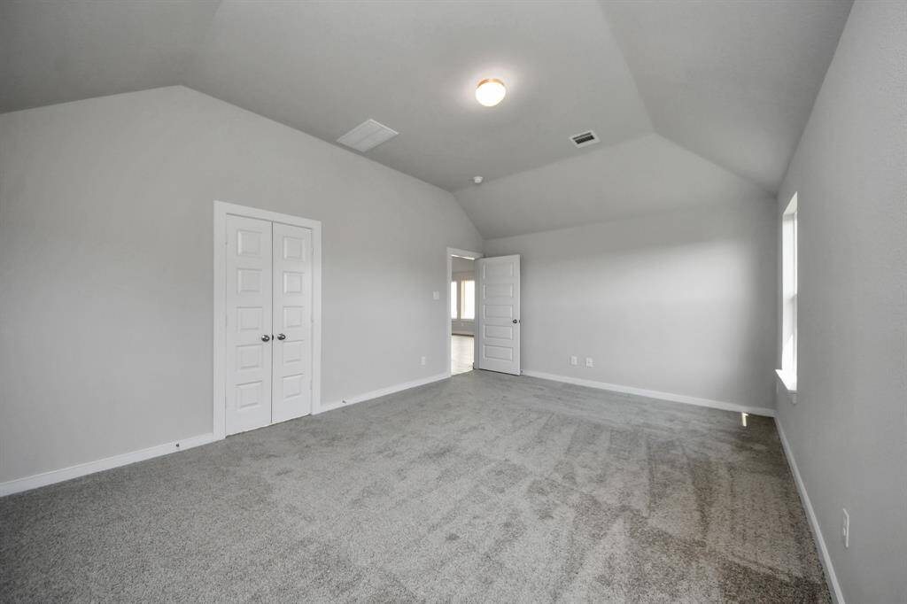 Escape and relax in the exquisite primary suite, a haven to unwind after a long day. The spacious room boasts plush carpeting, soothing paint tones, high ceilings, and expansive windows adorned with privacy blinds.