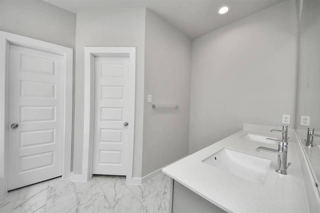 Experience a spa-like escape right in the heart of your primary bathroom. The expansive walk-in shower, surrounded by tile, and the distinctive garden tub with unique accents elevate your daily routine.