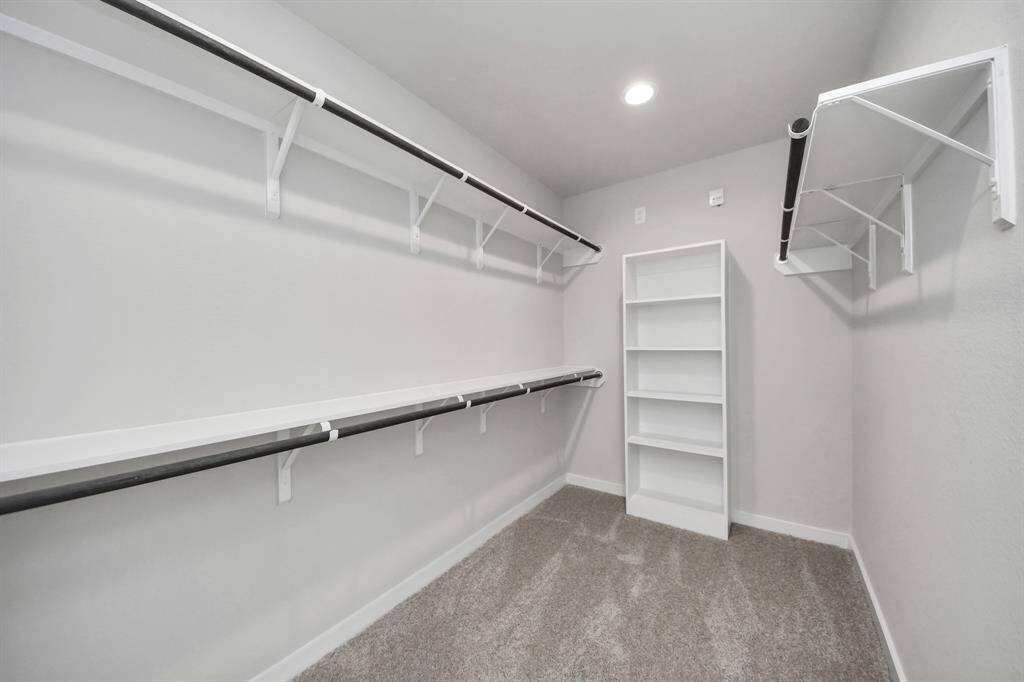 Walk-in closet that epitomizes luxury and practicality. This generously sized space features built-in shelving, offering abundant room for impeccable organization. High ceilings and recessed lighting create a bright and welcoming ambiance.