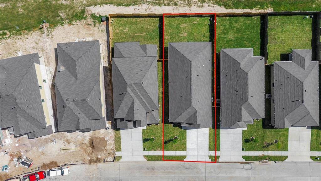 An aerial view of a spacious subdivision lot, highlighting a well-maintained yard and a fully fenced perimeter, offering both privacy and expansive outdoor space.