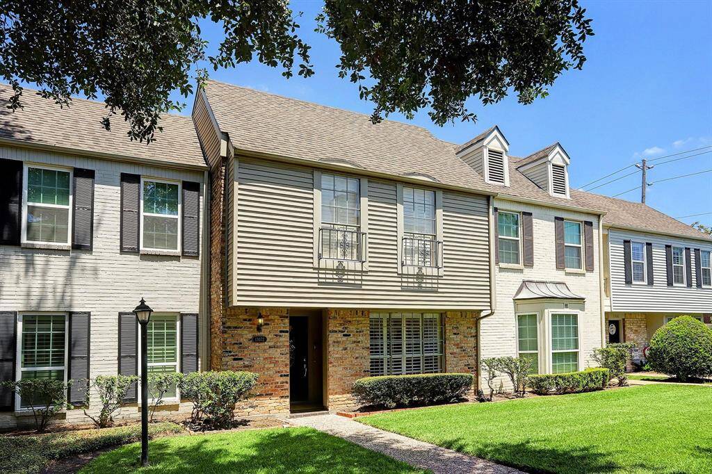 A welcoming exterior featuring a classic brick façade, neatly manicured landscaping, and a charming walkway leading to the entrance.