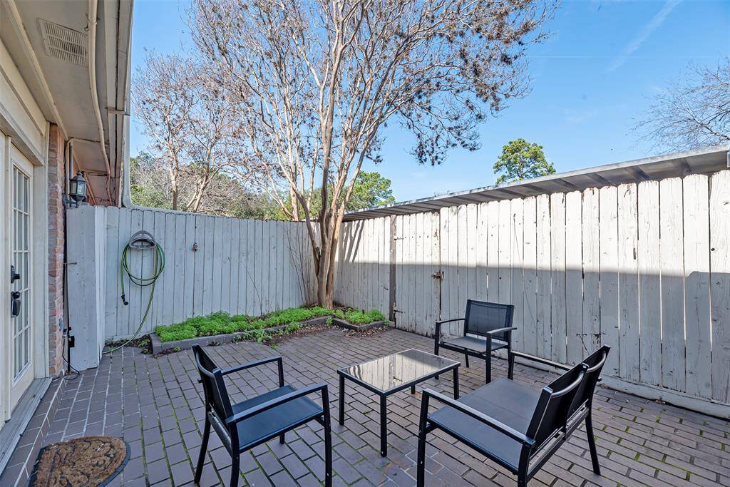 A different view of the patio showcasing the fenced perimeter and additional seating space.