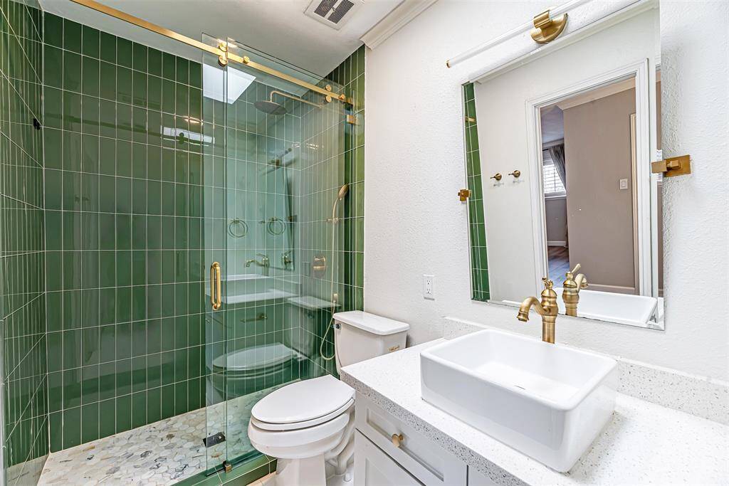 Luxurious master bathroom with modern finishes, a sleek shower, and ample lighting.