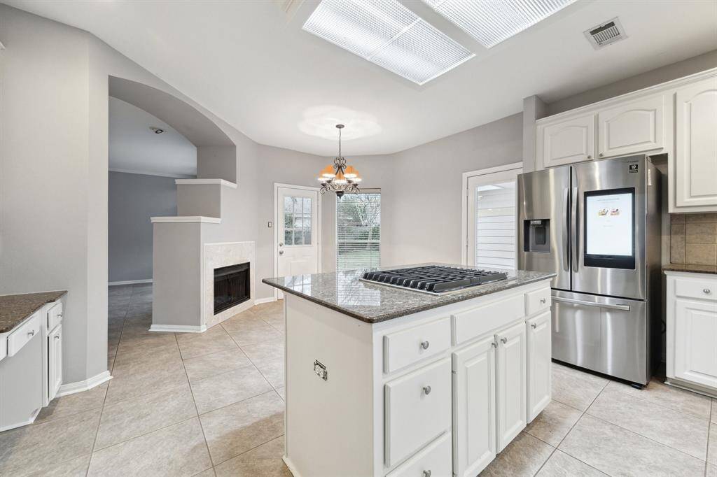 Kitchen with touch pad refrigerator and two way fireplace.
